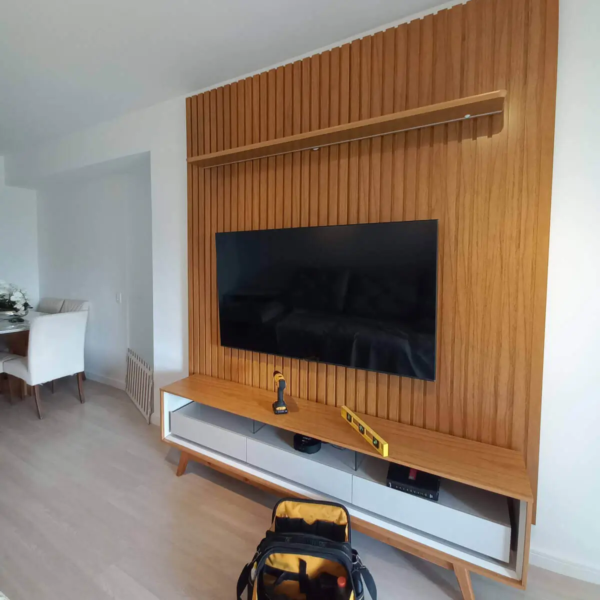 Profissional realizando instalação de painel para TV em residência no Rio de Janeiro.