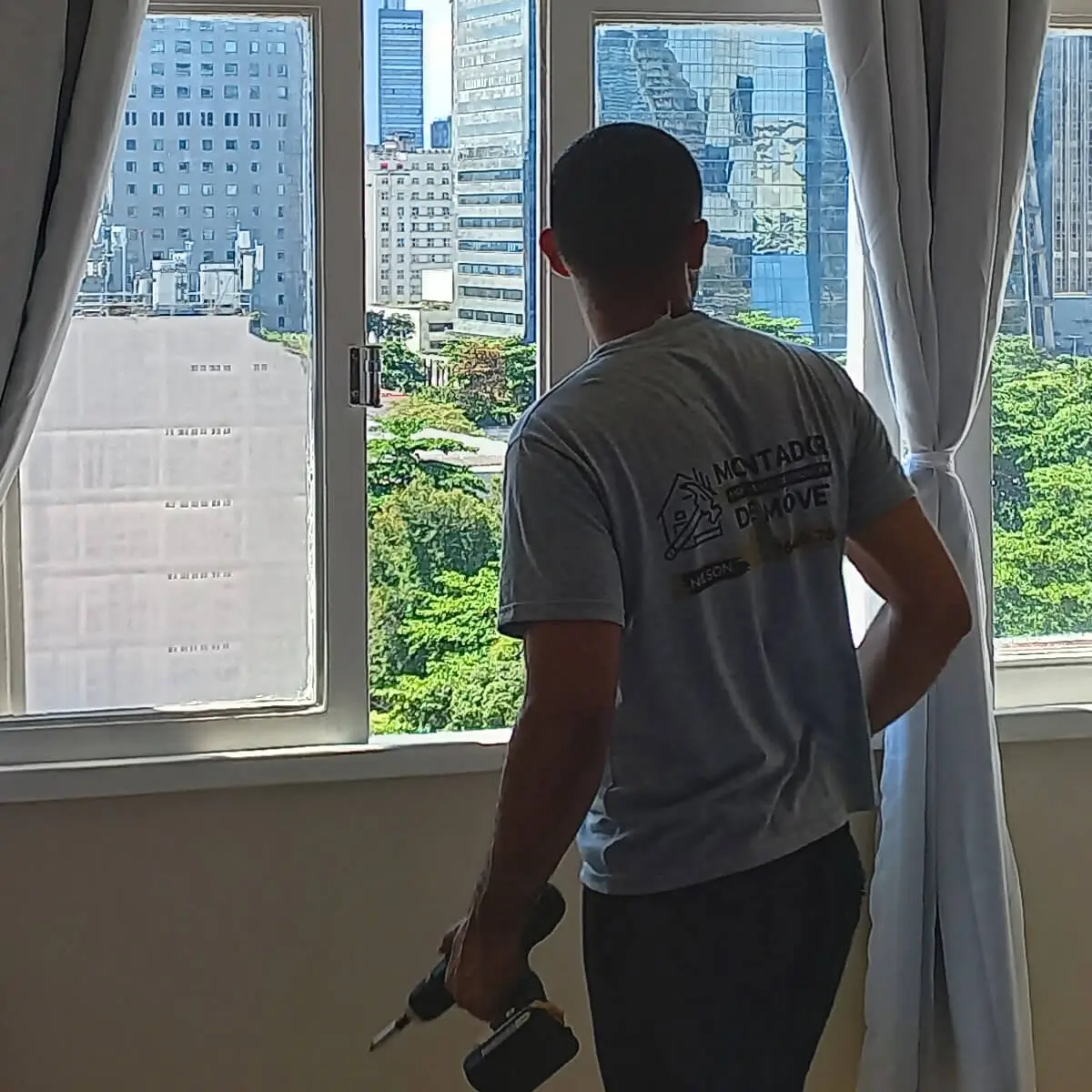 Profissional instalando varão de cortina em residência no Rio de Janeiro.